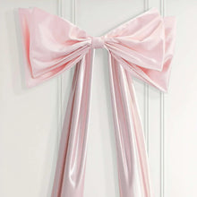 Pink satin bow with long ribbon streamers, close-up of center knot