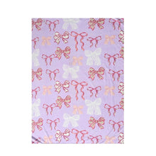 Lavender plush throw blanket with red bow and ribbon repeat pattern