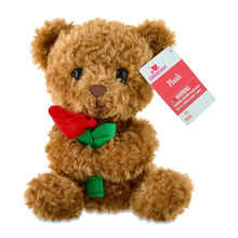Brown plush bear holding a red rose with green leaves, with gift tag