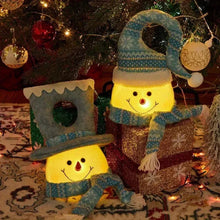 Lit plush snowman Christmas tree topper on a decorated Christmas tree