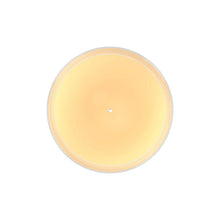 Round glass candle jar with smooth amber wax surface and small wick spot