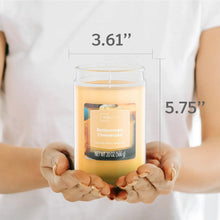 Scented jar candle held in hands, clear glass jar with buttercream cheesecake label