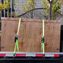 Green ratchet tie-down straps with black ratchets and S-hooks securing cargo