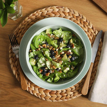 Green melamine bowl with salad, nested on a matching plate