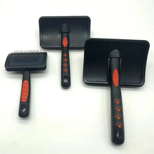 Set of slicker brushes with black bristle pads and red handled grips