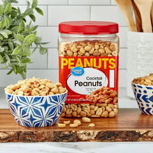 Roasted salted cocktail peanuts jar on kitchen counter, red lid and peanuts visible