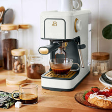 White espresso machine with black portafilter and steam wand, brewing into a cup