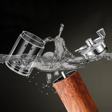 Portable manual coffee grinder with wooden body and stainless top, shown with splash