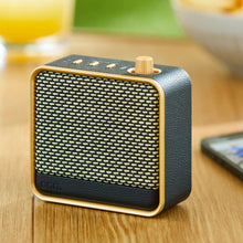 onn small Wi-Fi speaker, black mesh front with gold trim and raised top controls