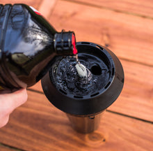 Mosquito repellent torch fuel pouring from bottle into black torch fuel holder