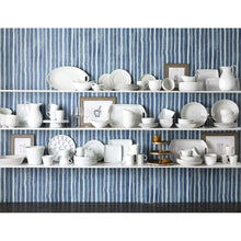 White oval porcelain serving tray with side handles displayed among white tableware