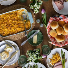 Salted butter pieces on plates alongside baked dishes and bread
