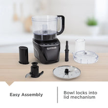 Food processor with accessories: clear bowl, feed tube, blade, and discs