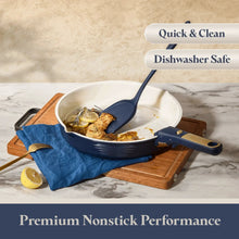 Blue ceramic frying pan with lid and handle, cooking utensil beside it.