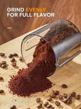 Electric grinder dispensing freshly ground coffee into a tray from the chute