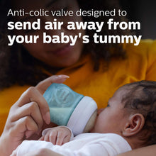 Blue Philips Avent baby bottle with natural response nipple held for feeding