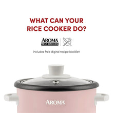 Pink rice cooker with black lid and top steam vent