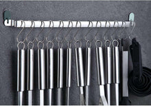 Stainless utensil rack with hooks, hanging ladles and spatulas in a row