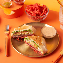Sandwich halves on a plate with tortilla chips and cheese dip in bowls
