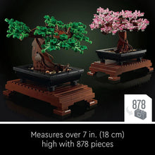Two LEGO Icons bonsai tree models on dark stands, with green and pink blossoms