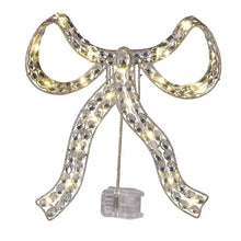 Silver jeweled bow tree topper with warm lights and an attached battery pack