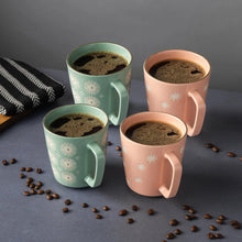 Set of four patterned mugs with mint green and blush pink exteriors and wide curved handles