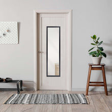 Black framed rectangle wall mirror inset in entryway.
