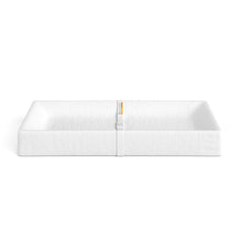 White quilted changing pad with central seam and small yellow label strip