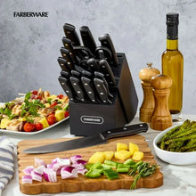 Knife block set with black-handled knives and kitchen shears on a countertop