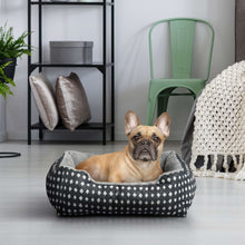 Plush pet bed with black fabric and white diamond pattern, gray cushioned interior