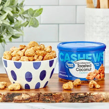Toasted coconut cashews in patterned bowl with blue-lidded snack container