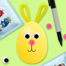 Easter bunny decoration with yellow face, pom ears, and candy wrappers