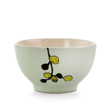 Green stoneware bowl with floral branch motif in black and yellow-green