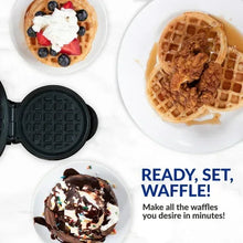 Mini waffle maker with open lid and waffles topped with berries