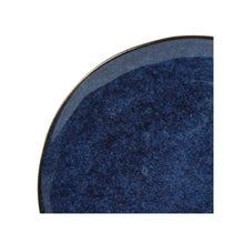 Blue stoneware dinner plate interior with speckled texture and dark rim
