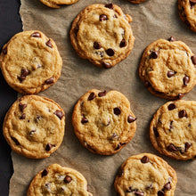 Chocolate chip cookies arranged on parchment