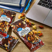 Mixed nuts pouches with scattered nuts on wooden surface
