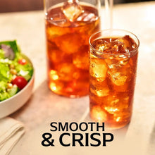 Glasses of iced tea with ice cubes and pitcher behind