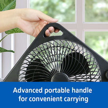 Black table fan with built-in carry handle, held by a hand
