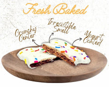 Crunchy dog treats on a wooden tray with white frosting and colorful sprinkles