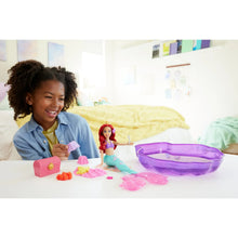 Mermaid doll with purple seashell pool and moldable sand pieces on tabletop