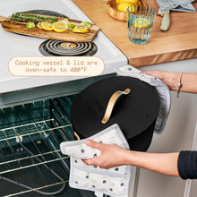 Black multi-cooker pot with lid off and gray oven mitt, stove-top setting