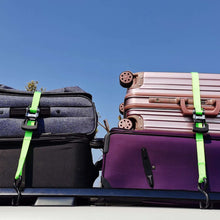 Green ratchet tie-down straps with black ratchets and S-hooks securing bags on a trailer