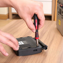 Hand driving a screw with precision screwdriver on a device base