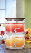 Stacking glass dispenser with acacia lid, red and orange drinks, and two chrome spigots