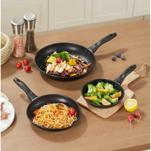 Black nonstick skillets with handles, filled with cooked food