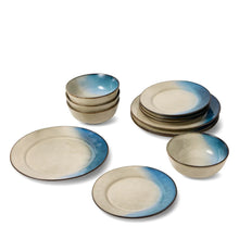 Reactive ceramic dinnerware set featuring bowls and plates in beige with blue swirls
