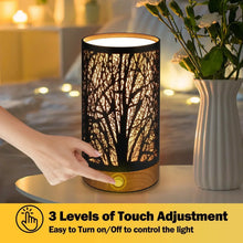 Table lamp with illuminated black cylindrical shade, touch control button on the base.