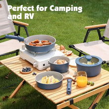Navy ceramic pots and pans with detachable handles on a camping table setup.