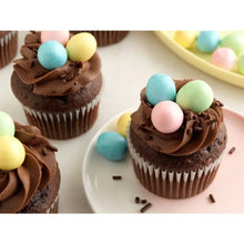 Candy coated milk chocolate eggs on chocolate cupcakes, pastel shell pieces